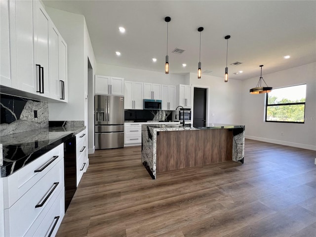 kitchen with backsplash, stainless steel appliances, dark wood-type flooring, white cabinetry, and pendant lighting