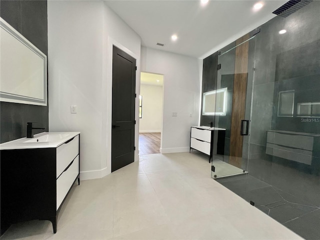 bathroom with a shower with shower door, vanity, and tile floors