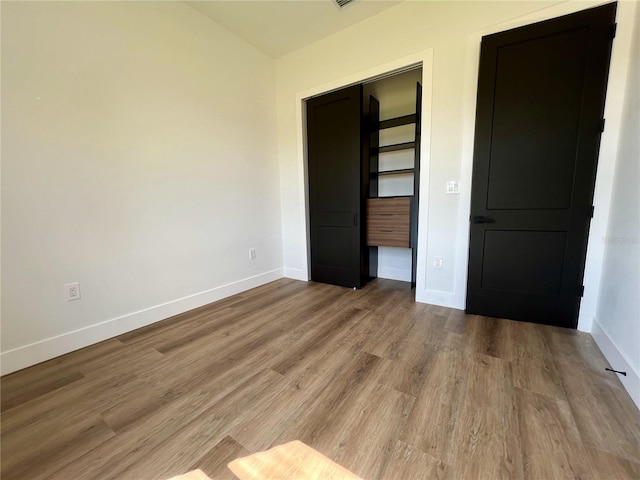 unfurnished bedroom with hardwood / wood-style floors and a closet