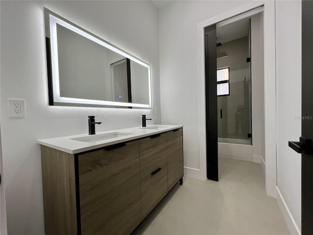 bathroom with a shower with door, oversized vanity, concrete floors, and double sink