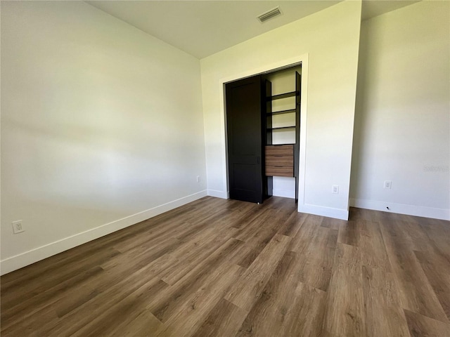 unfurnished bedroom featuring a closet and dark wood-type flooring