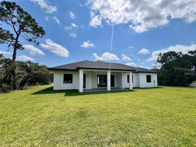 rear view of house featuring a patio and a lawn