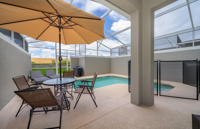 view of swimming pool with glass enclosure and a patio area