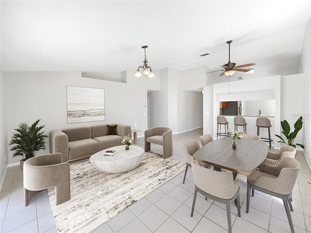 living room featuring lofted ceiling, ceiling fan with notable chandelier, and light tile flooring