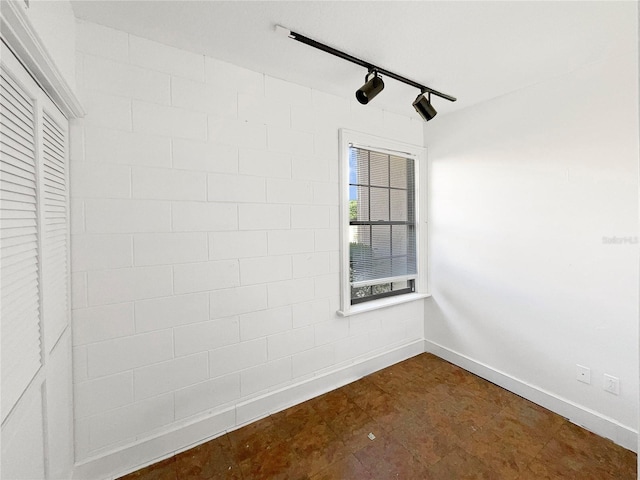 tiled spare room with rail lighting