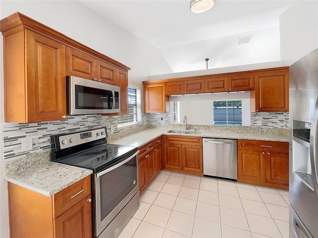 kitchen featuring light tile floors, stainless steel appliances, backsplash, sink, and light stone counters