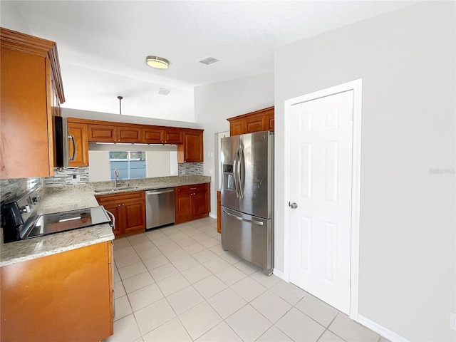 kitchen featuring appliances with stainless steel finishes, light tile floors, sink, and backsplash