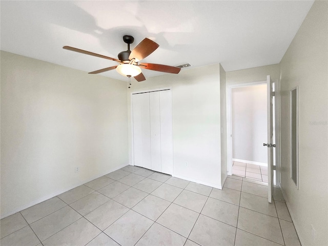 tiled spare room with ceiling fan