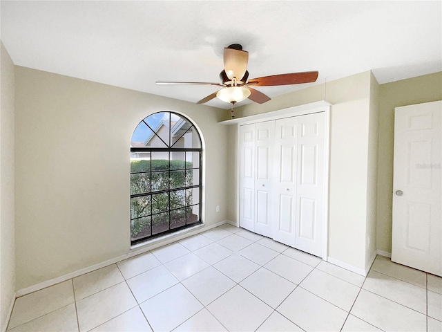 unfurnished bedroom featuring a closet, ceiling fan, and light tile flooring