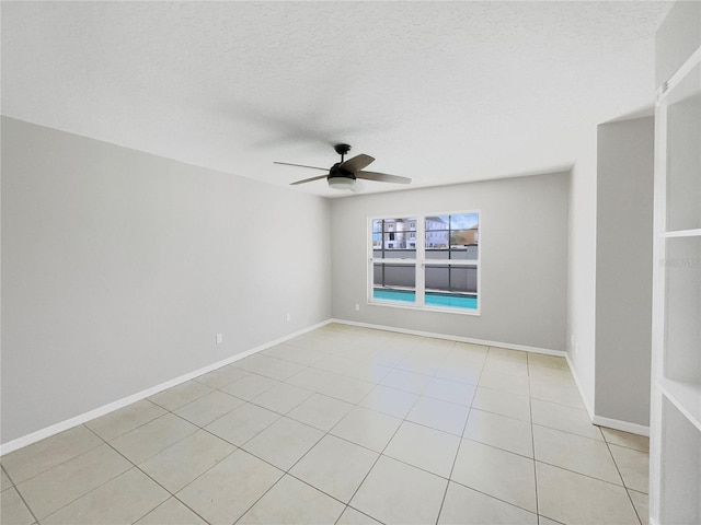 empty room featuring light tile floors, a textured ceiling, and ceiling fan