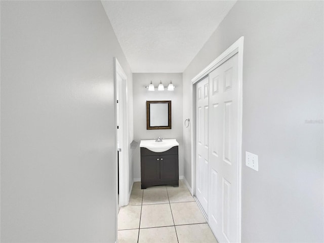 hallway with light tile flooring and sink