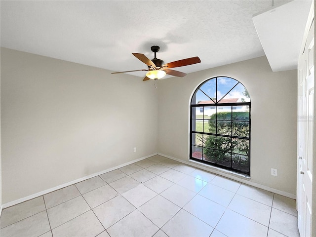 tiled empty room featuring ceiling fan and a textured ceiling