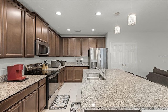 687 Campo Ln, Davenport, FL 33837 - kitchen with stainless steel appliances, recessed lighting, a center island with sink, light stone countertops, and hanging light fixtures