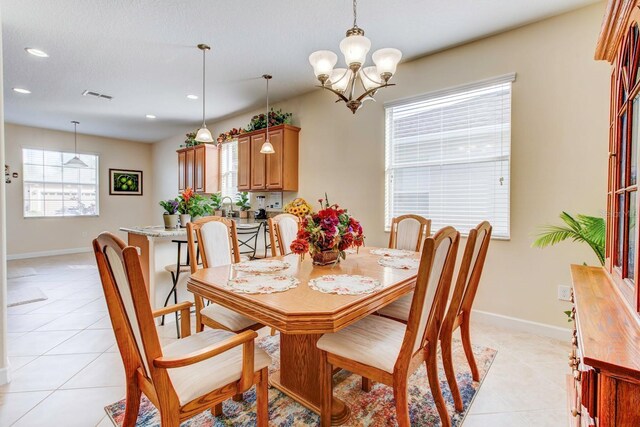 tiled dining space with sink and a chandelier