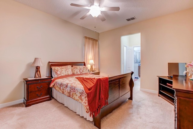 bedroom featuring a textured ceiling, ceiling fan, and light carpet