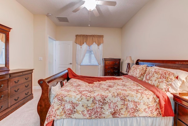 bedroom featuring a textured ceiling, ceiling fan, and carpet