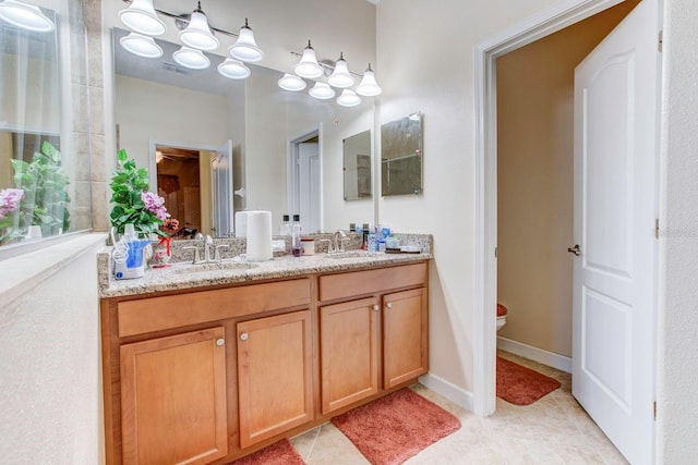 bathroom featuring vanity with extensive cabinet space, dual sinks, toilet, and tile flooring