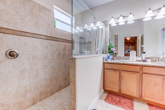 bathroom with vanity, a tile shower, and tile floors