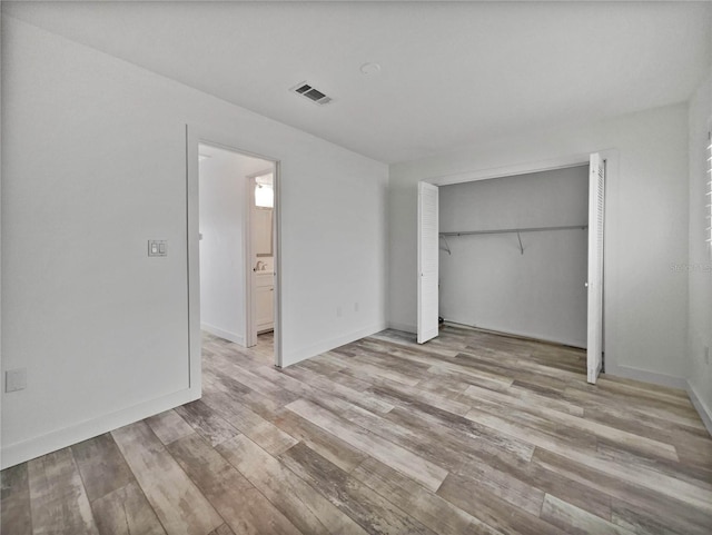 unfurnished bedroom with a closet and light hardwood / wood-style floors