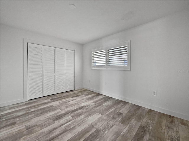 unfurnished bedroom with a closet and light hardwood / wood-style flooring