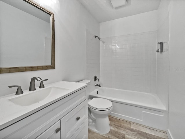 full bathroom featuring oversized vanity, tiled shower / bath, toilet, and hardwood / wood-style floors