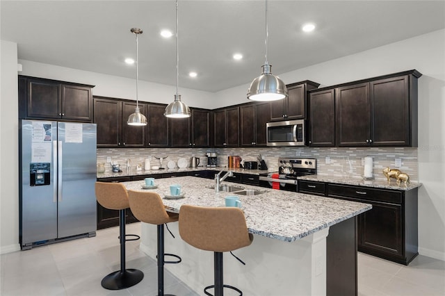 kitchen featuring decorative light fixtures, appliances with stainless steel finishes, light tile flooring, and tasteful backsplash