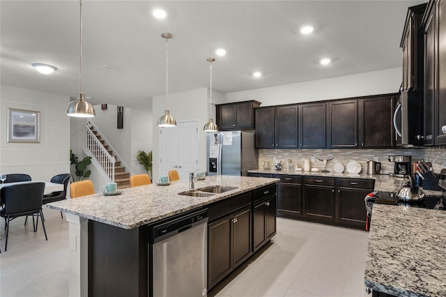 kitchen featuring appliances with stainless steel finishes, sink, pendant lighting, and tasteful backsplash