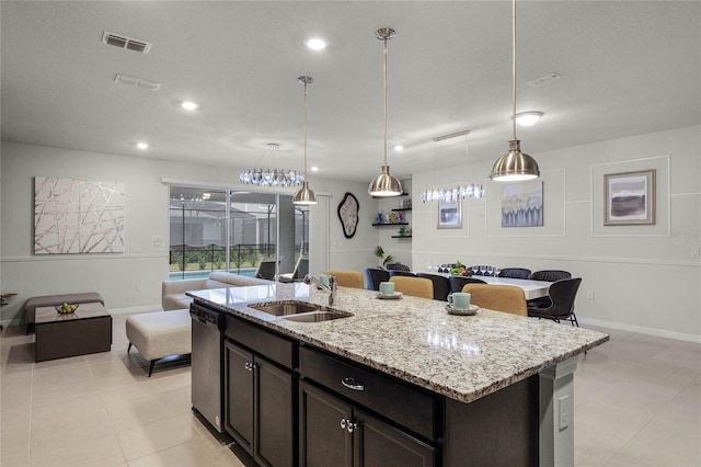 kitchen with sink, stainless steel dishwasher, hanging light fixtures, an island with sink, and light stone countertops