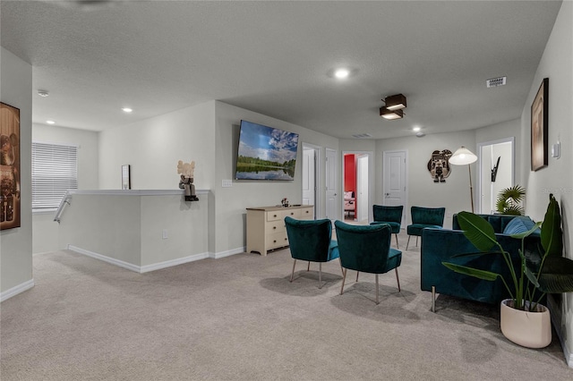 carpeted dining room featuring a textured ceiling