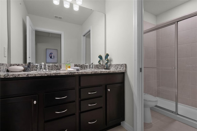 bathroom with an enclosed shower, toilet, tile floors, and double vanity