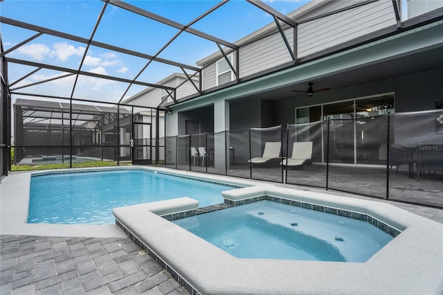 view of swimming pool with a patio, ceiling fan, an in ground hot tub, and glass enclosure