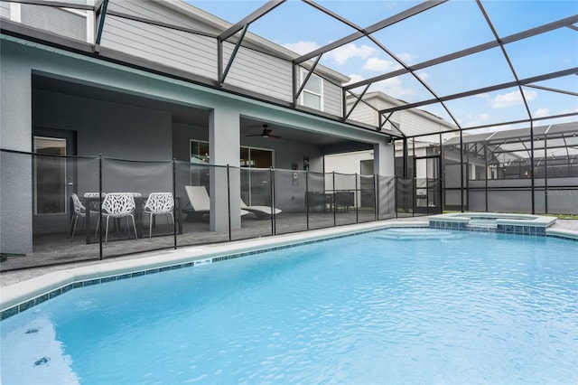 view of swimming pool with a patio, glass enclosure, an in ground hot tub, and ceiling fan