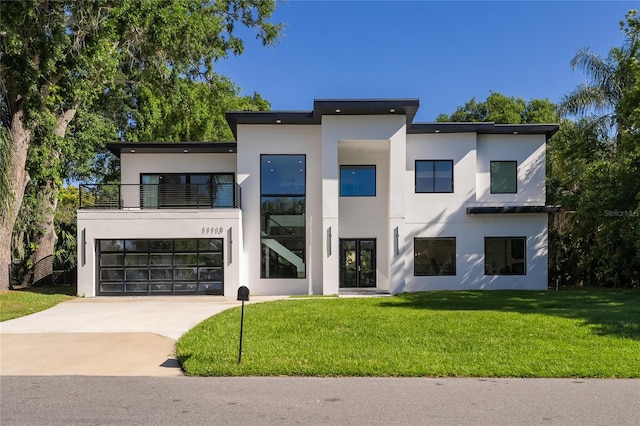 contemporary home with a balcony, a front lawn, and a garage