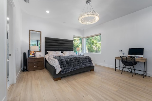 bedroom with light hardwood / wood-style flooring and a chandelier