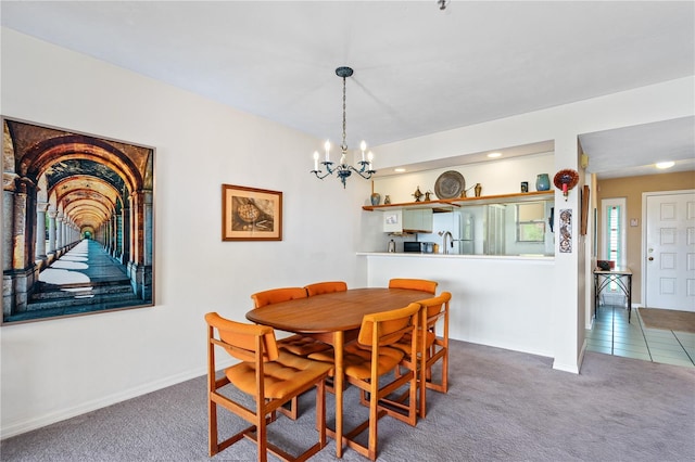 carpeted dining area with an inviting chandelier