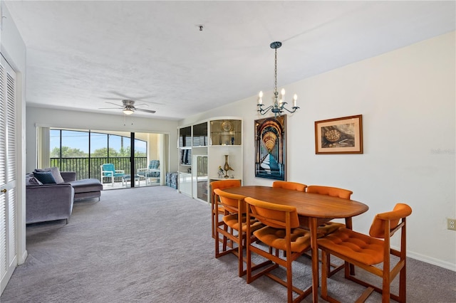 dining area featuring dark carpet and ceiling fan with notable chandelier