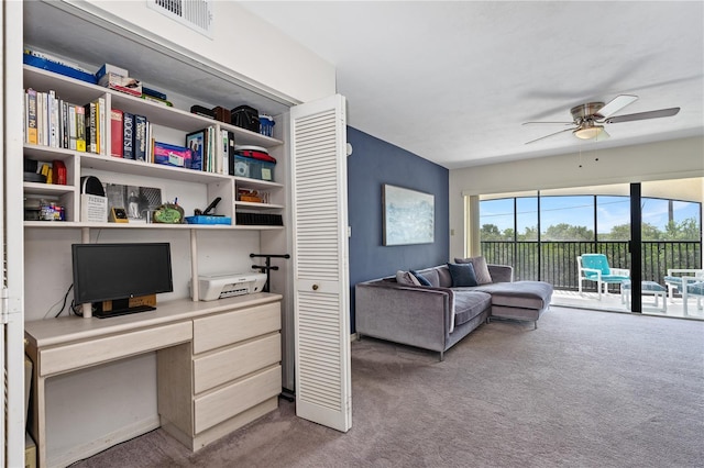 carpeted office featuring ceiling fan and built in desk