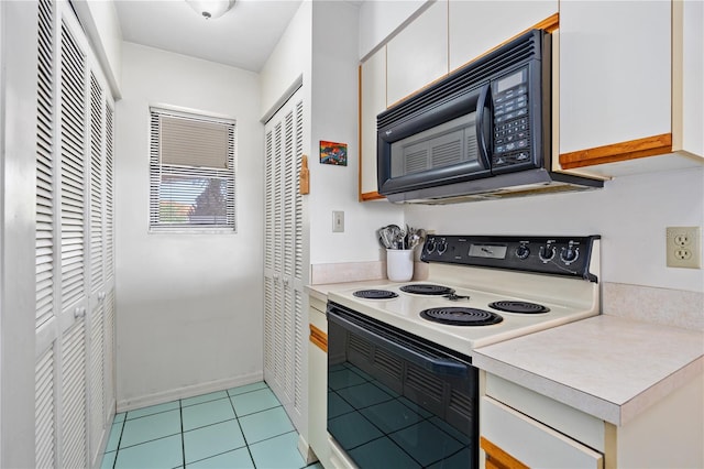 kitchen featuring white cabinets, white range with electric stovetop, and light tile flooring