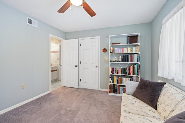 living area with ceiling fan and light carpet