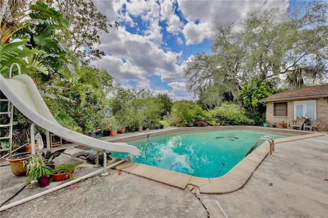 view of swimming pool featuring a patio and a water slide