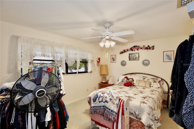 carpeted bedroom with ceiling fan and a textured ceiling