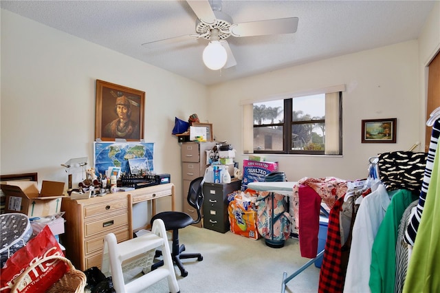 carpeted office space with ceiling fan and a textured ceiling