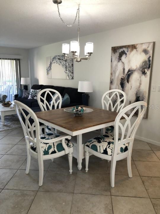 tiled dining area featuring a notable chandelier