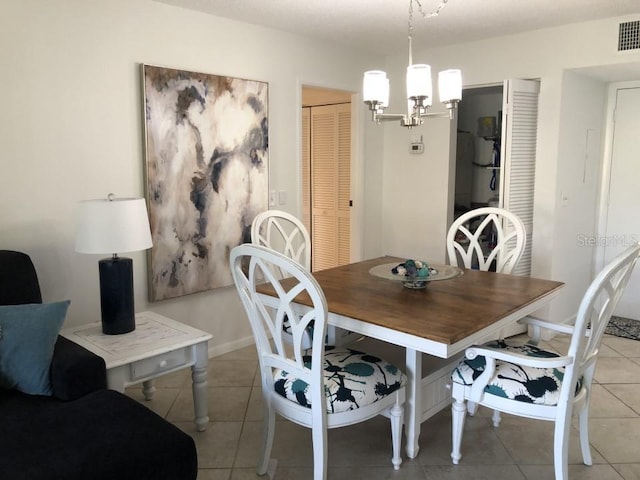 tiled dining space with a chandelier