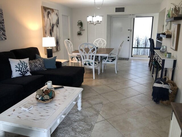 living room featuring light tile floors and an inviting chandelier