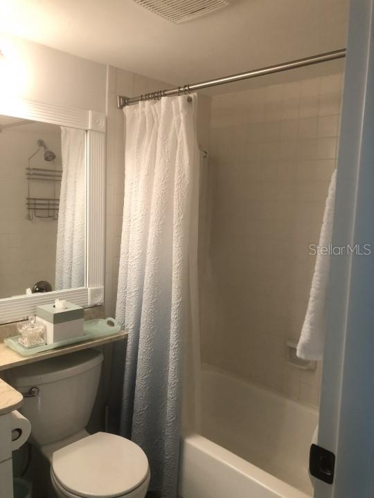 full bathroom featuring shower / tub combo with curtain, vanity, and toilet