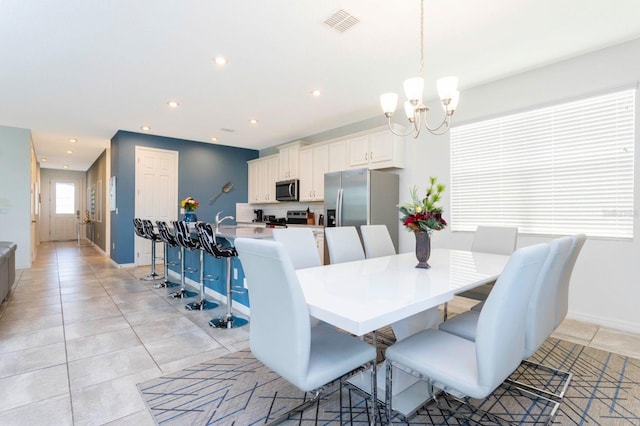 tiled dining space with a chandelier and sink