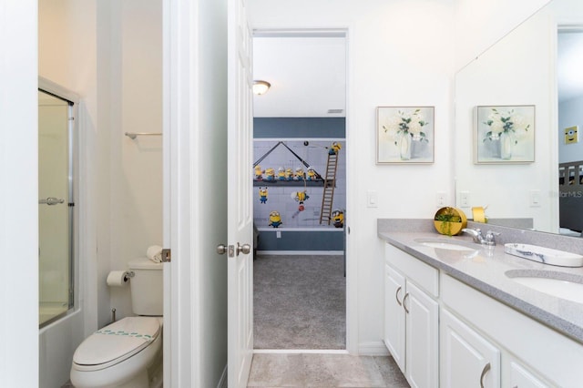 full bathroom with bath / shower combo with glass door, toilet, vanity with extensive cabinet space, tile flooring, and double sink