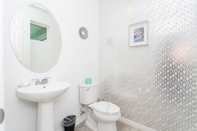 bathroom featuring tile flooring and toilet