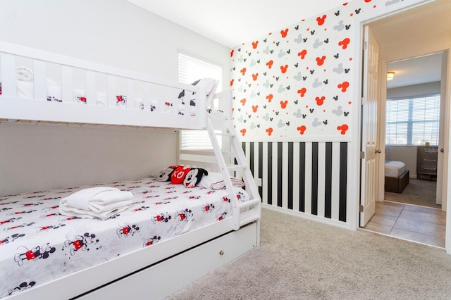 bedroom featuring ensuite bath and light carpet